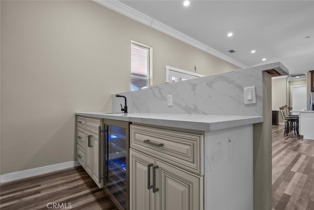 kitchen featuring tasteful backsplash, ornamental molding, beverage cooler, sink, and dark hardwood / wood-style floors