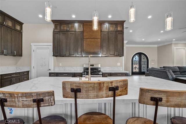 kitchen with french doors, a center island with sink, dark brown cabinets, and pendant lighting