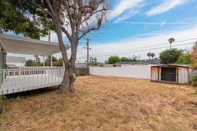 view of yard featuring a deck and a storage shed