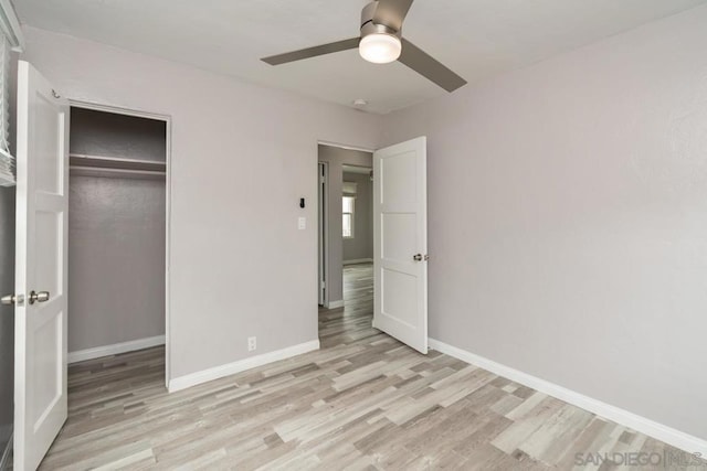 unfurnished bedroom with ceiling fan, light hardwood / wood-style floors, and a closet