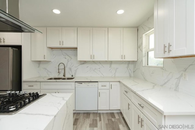 kitchen featuring gas cooktop, stainless steel fridge, white dishwasher, sink, and white cabinetry