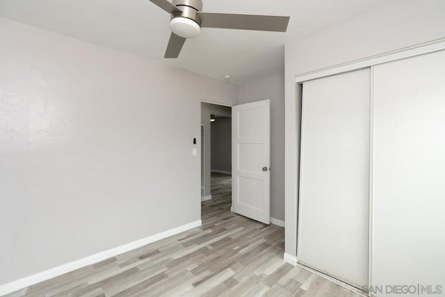 unfurnished bedroom with ceiling fan, a closet, and light hardwood / wood-style floors