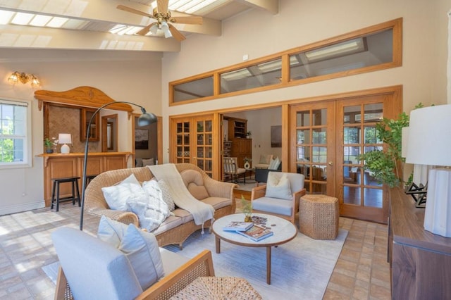 living room with ceiling fan, french doors, and beamed ceiling