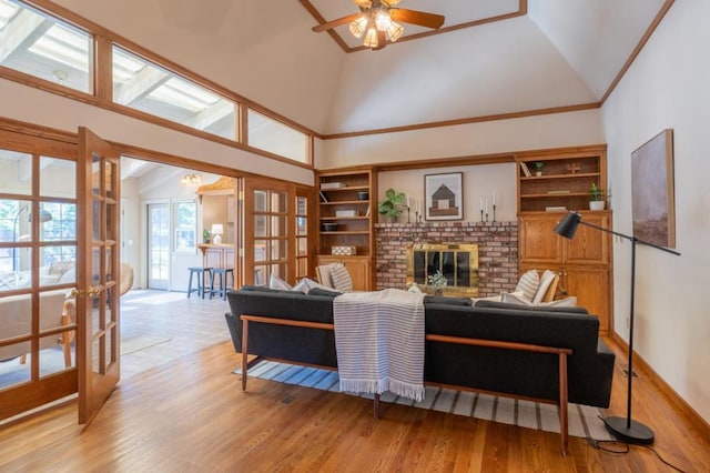 living room with ceiling fan, light hardwood / wood-style flooring, high vaulted ceiling, and french doors