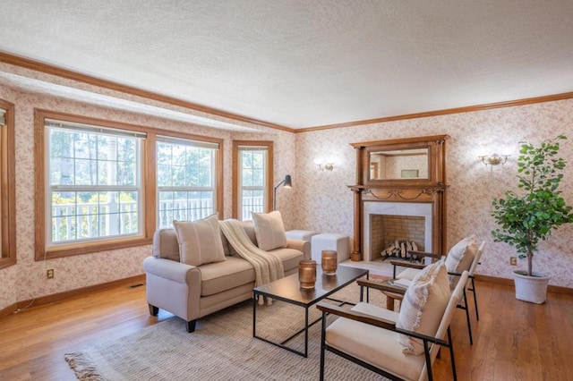 living room featuring a textured ceiling, a premium fireplace, crown molding, and light hardwood / wood-style flooring