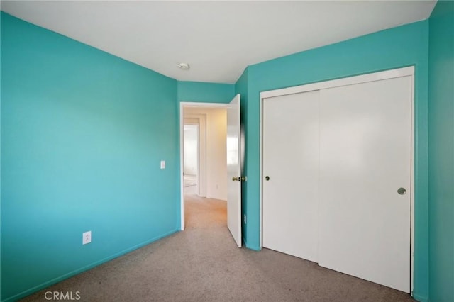 unfurnished bedroom featuring carpet flooring and a closet