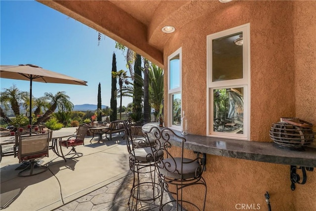 view of patio / terrace with outdoor dining space and a mountain view