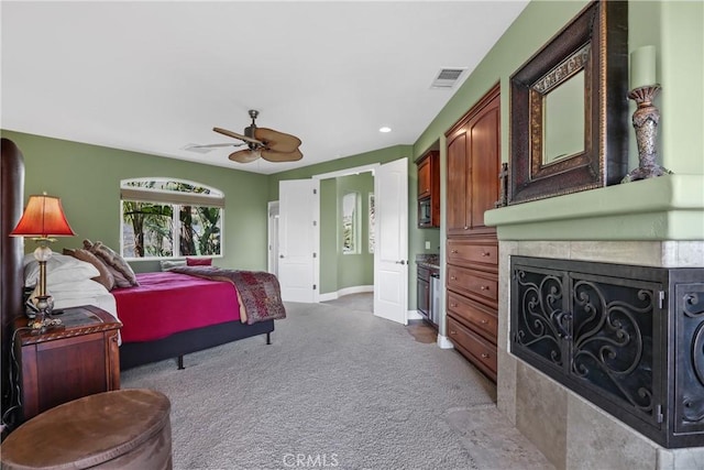 carpeted bedroom featuring ceiling fan, visible vents, and baseboards