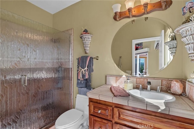 bathroom featuring a stall shower, vanity, and toilet