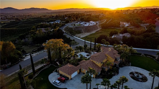 aerial view at dusk featuring a mountain view