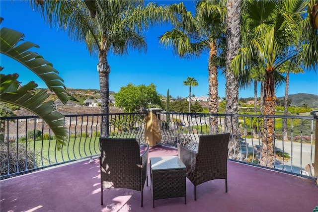 view of patio featuring a mountain view and a balcony