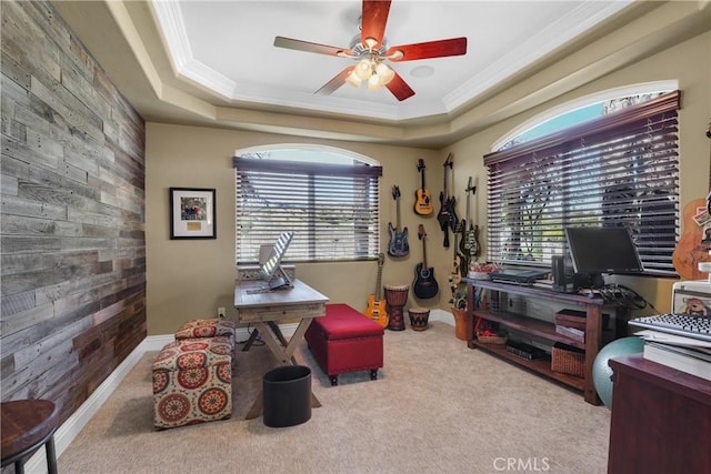 home office featuring a tray ceiling, wood walls, and a wealth of natural light