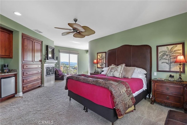 bedroom with light carpet, visible vents, a ceiling fan, refrigerator, and access to outside