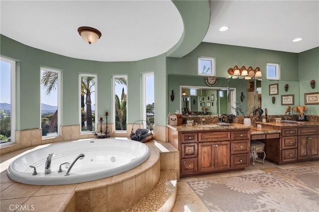 bathroom featuring recessed lighting, vanity, and a tub with jets