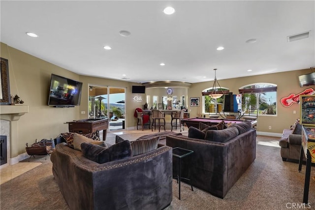 living room featuring carpet, a fireplace with flush hearth, visible vents, and recessed lighting