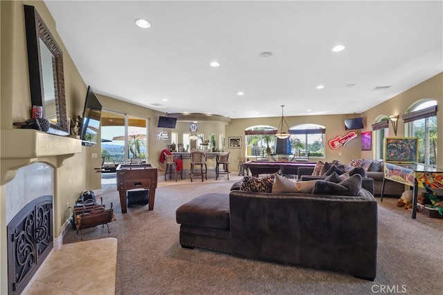 living room featuring a fireplace with flush hearth, a wealth of natural light, carpet, and recessed lighting