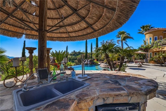 view of patio featuring an outdoor pool and a sink