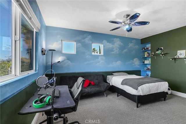 carpeted bedroom with multiple windows, ceiling fan, and baseboards