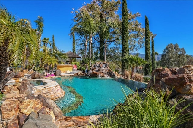 outdoor pool featuring a gazebo and an in ground hot tub