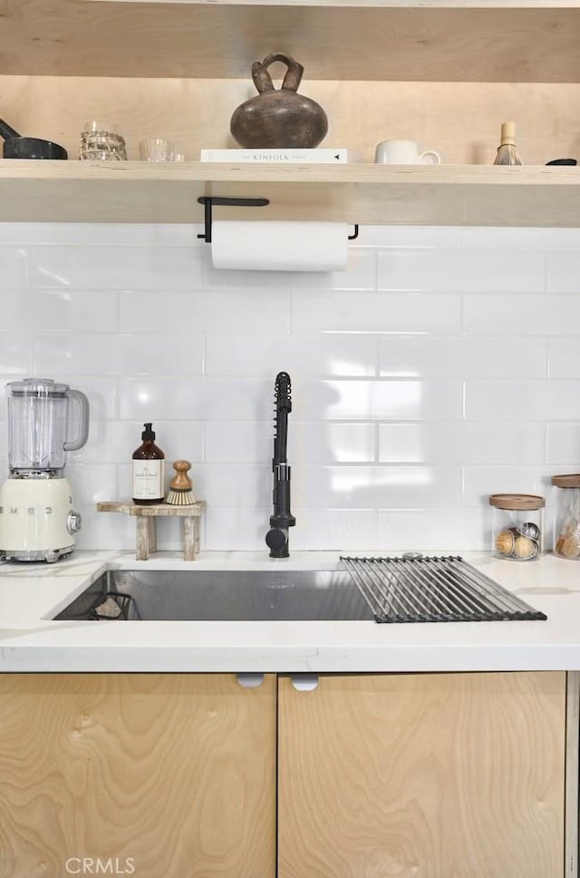 interior details featuring tasteful backsplash and sink