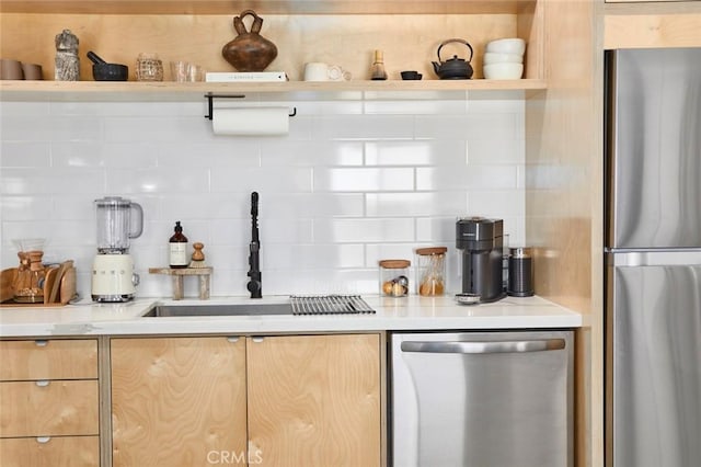 kitchen featuring decorative backsplash, light brown cabinets, stainless steel appliances, and sink