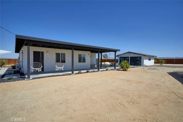 rear view of property with a patio and an outdoor structure