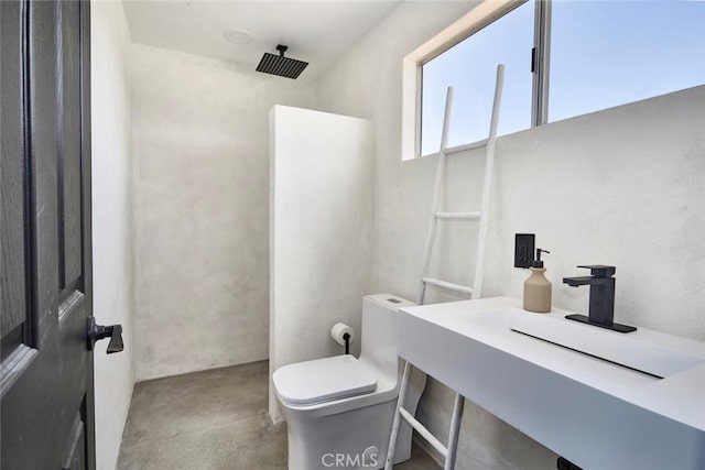 bathroom featuring concrete floors, toilet, and walk in shower