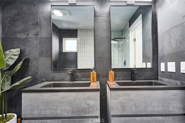 bathroom with vanity, tile walls, and walk in shower