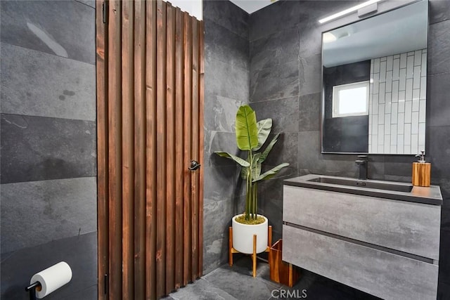 bathroom featuring vanity and tile walls