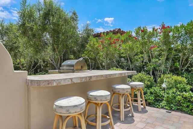 view of patio featuring exterior bar, area for grilling, and grilling area