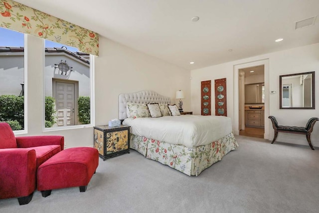 carpeted bedroom featuring ensuite bathroom, multiple windows, and lofted ceiling