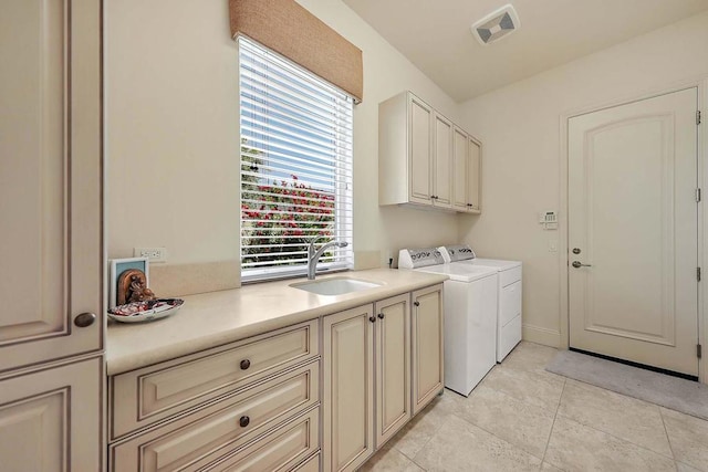 laundry room featuring cabinets, sink, light tile patterned flooring, and washing machine and clothes dryer