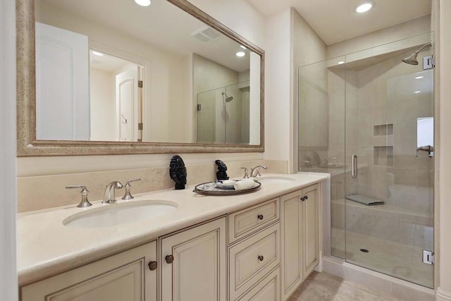 bathroom with a shower with door, vanity, and tile patterned flooring