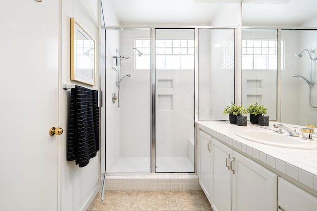 bathroom featuring tile patterned flooring, plenty of natural light, an enclosed shower, and vanity