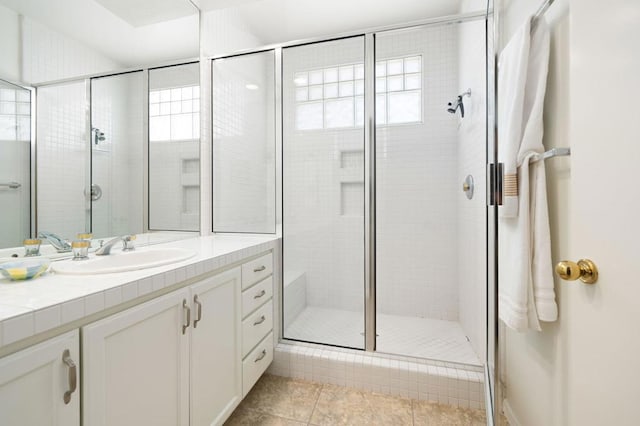 bathroom featuring tile patterned floors, a shower with door, vanity, and a healthy amount of sunlight