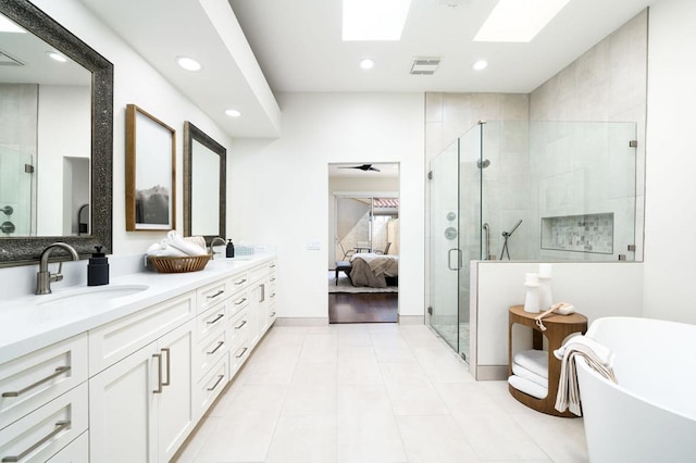 bathroom featuring vanity, a skylight, tile patterned flooring, ceiling fan, and independent shower and bath