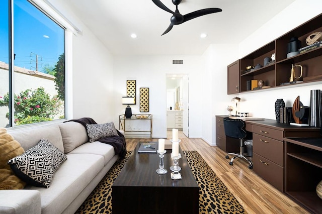 living room featuring ceiling fan and light hardwood / wood-style floors