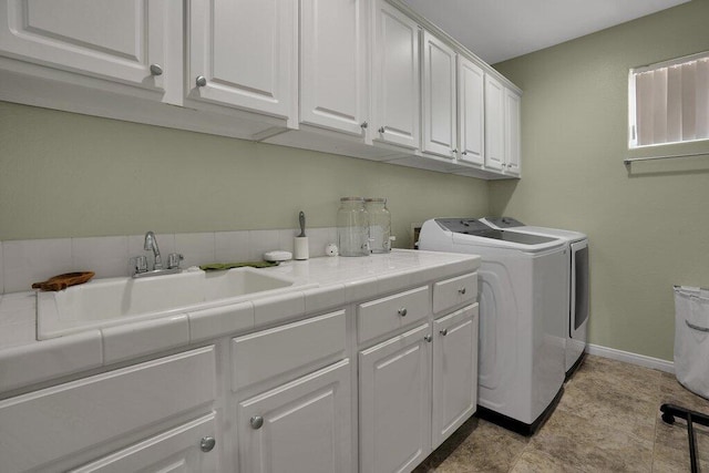 laundry area with washer and dryer, sink, and cabinets