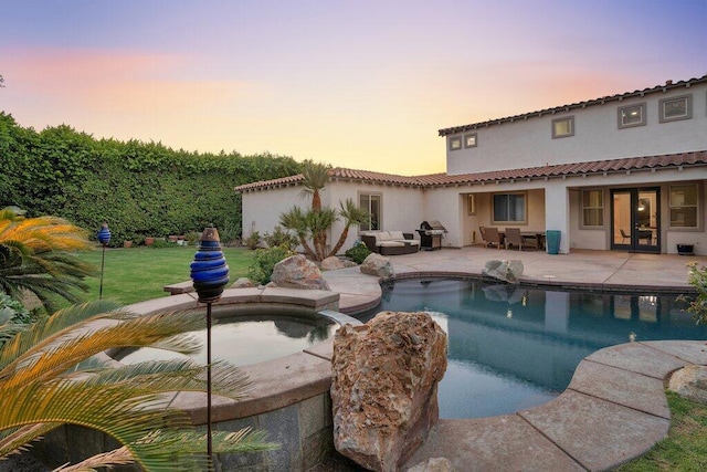 pool at dusk with a patio area and a grill