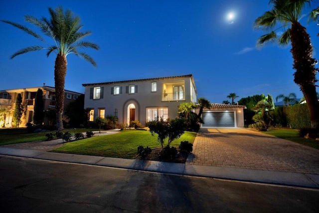 mediterranean / spanish home with a garage and a front lawn