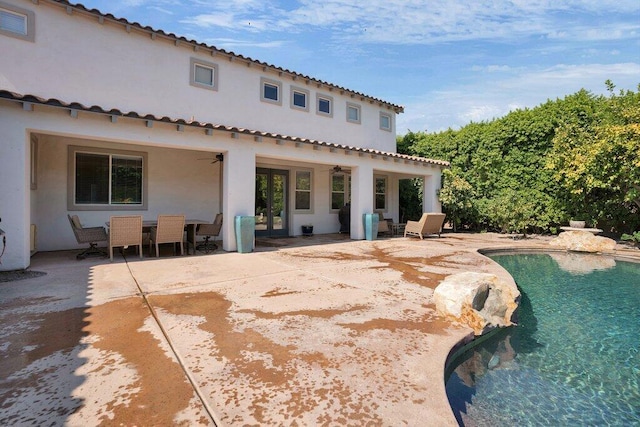 back of property with ceiling fan and a patio area