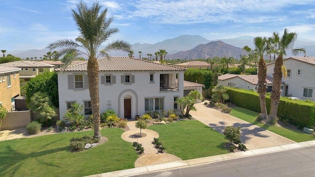 mediterranean / spanish house with a mountain view, a balcony, and a front yard