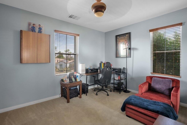 office with a wealth of natural light, ceiling fan, and light carpet