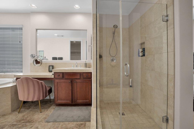 bathroom featuring tile patterned flooring, shower with separate bathtub, and vanity