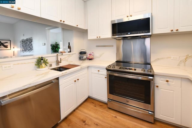 kitchen featuring sink, white cabinets, light hardwood / wood-style floors, and appliances with stainless steel finishes