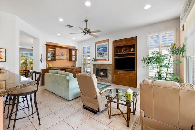 tiled living room with built in shelves and ceiling fan