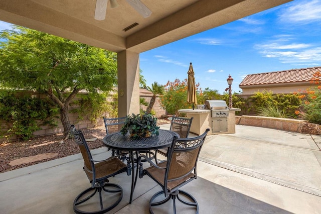 view of patio / terrace with exterior kitchen, area for grilling, and ceiling fan