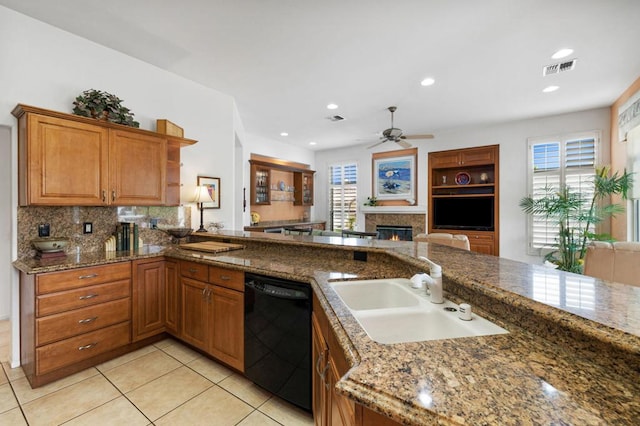 kitchen with black dishwasher, light tile patterned flooring, sink, and dark stone countertops