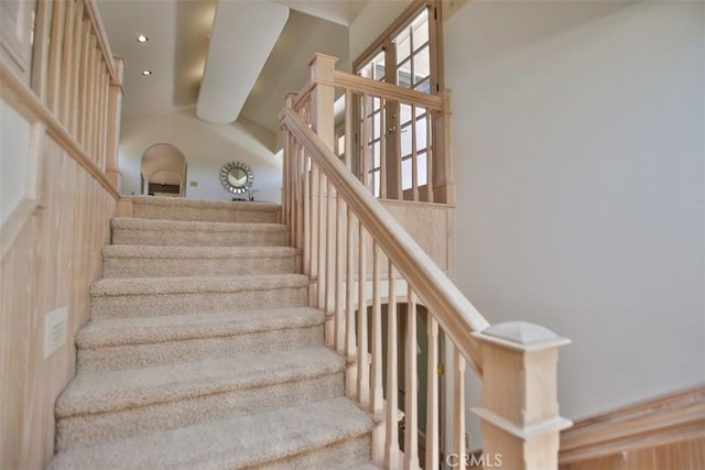 staircase featuring a high ceiling