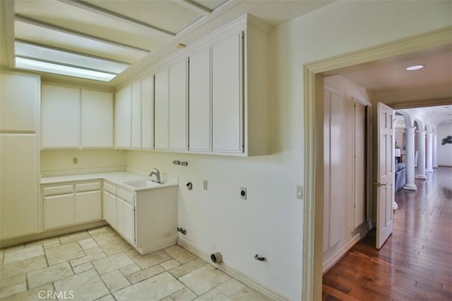 laundry area with light hardwood / wood-style floors, hookup for a gas dryer, cabinets, and hookup for an electric dryer